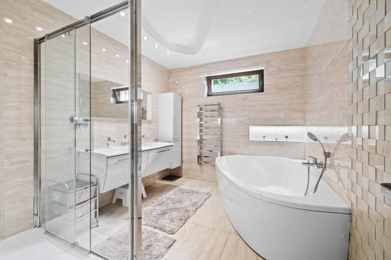 Luxusná kúpeľňa s vaňou, sprchovacím kútom a dvojitým umývadlom v rodinnom dome.