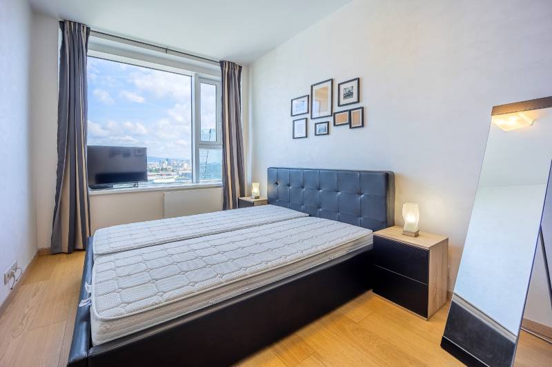 Spálňa s podlahou s dreveným dekorom v 3-izbovom byte s panoramatickým výhľadom.