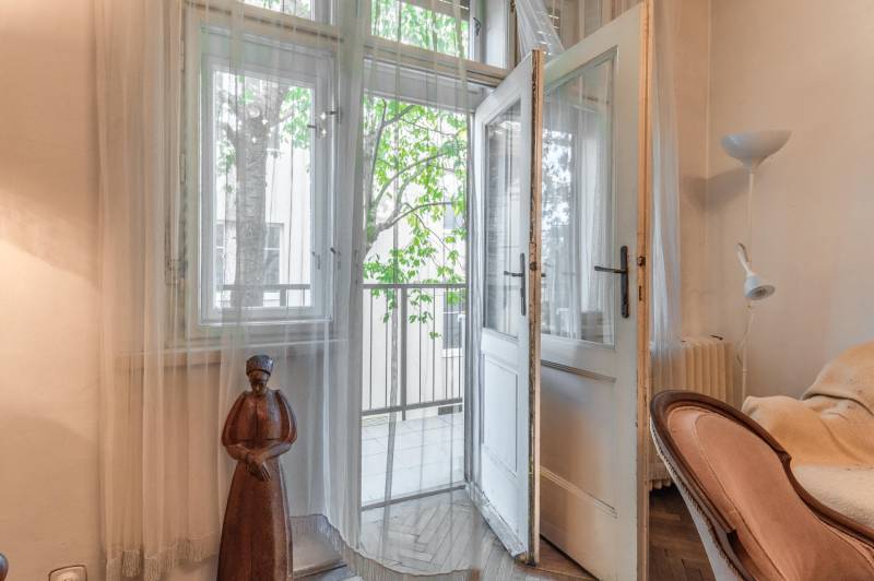 Interiér 3-izbového bytu s podlahou s dreveným dekorom, otvorené dvere na balkón.