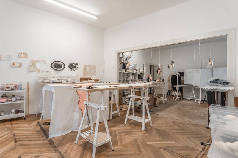 Pracovný ateliér s dekoráciami a podlahou s dreveným dekorom v 3-izbovom byte.