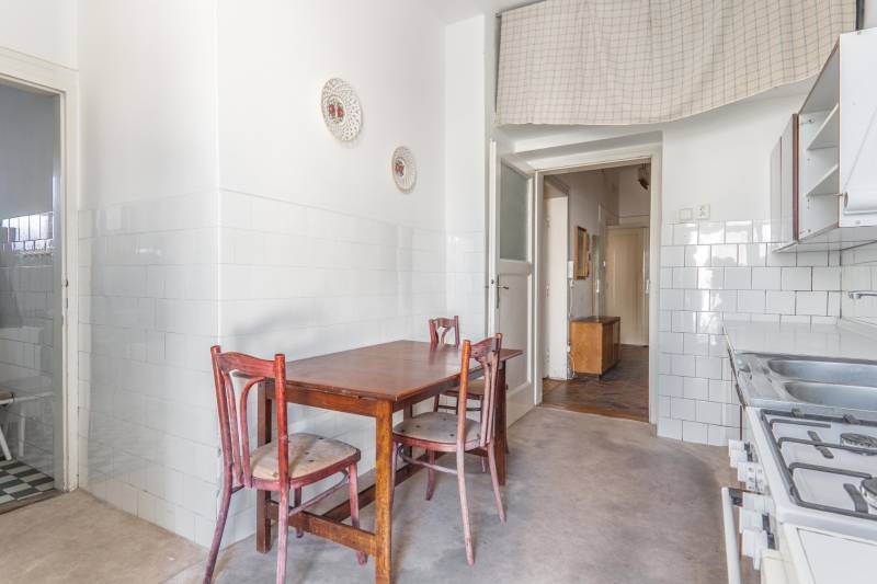 Kuchyňa v 3-izbovom byte s dreveným stolom a tromi stoličkami.