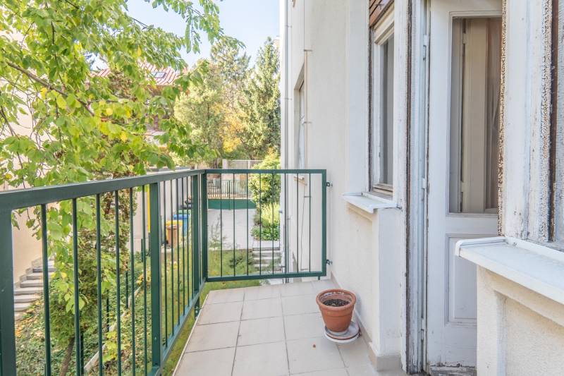 Balkón 3-izbového bytu s kvetináčom a výhľadom na zelený dvor.