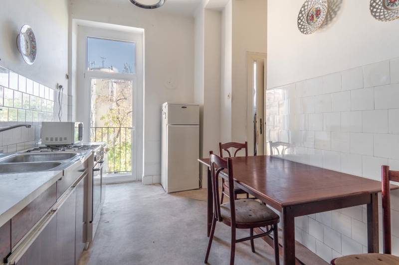 Kuchyňa v 3-izbovom byte s nábytkom a veľkým oknom poskytujúcim prírodné svetlo.